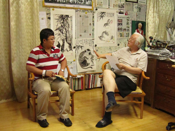 《艺术天成》主编杨洋正在与李燕先生（右一）交谈