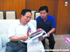 李建国在曹明冉大型画展贵宾室认真翻阅《艺术天成》杂志